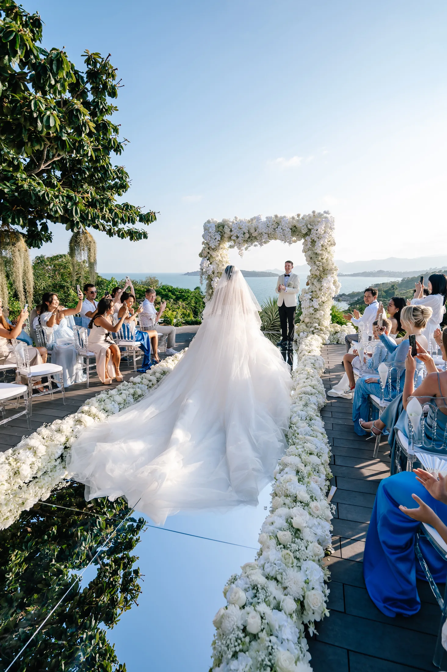 Bride walking down the aisle toward the groom at a destination wedding in Thailand