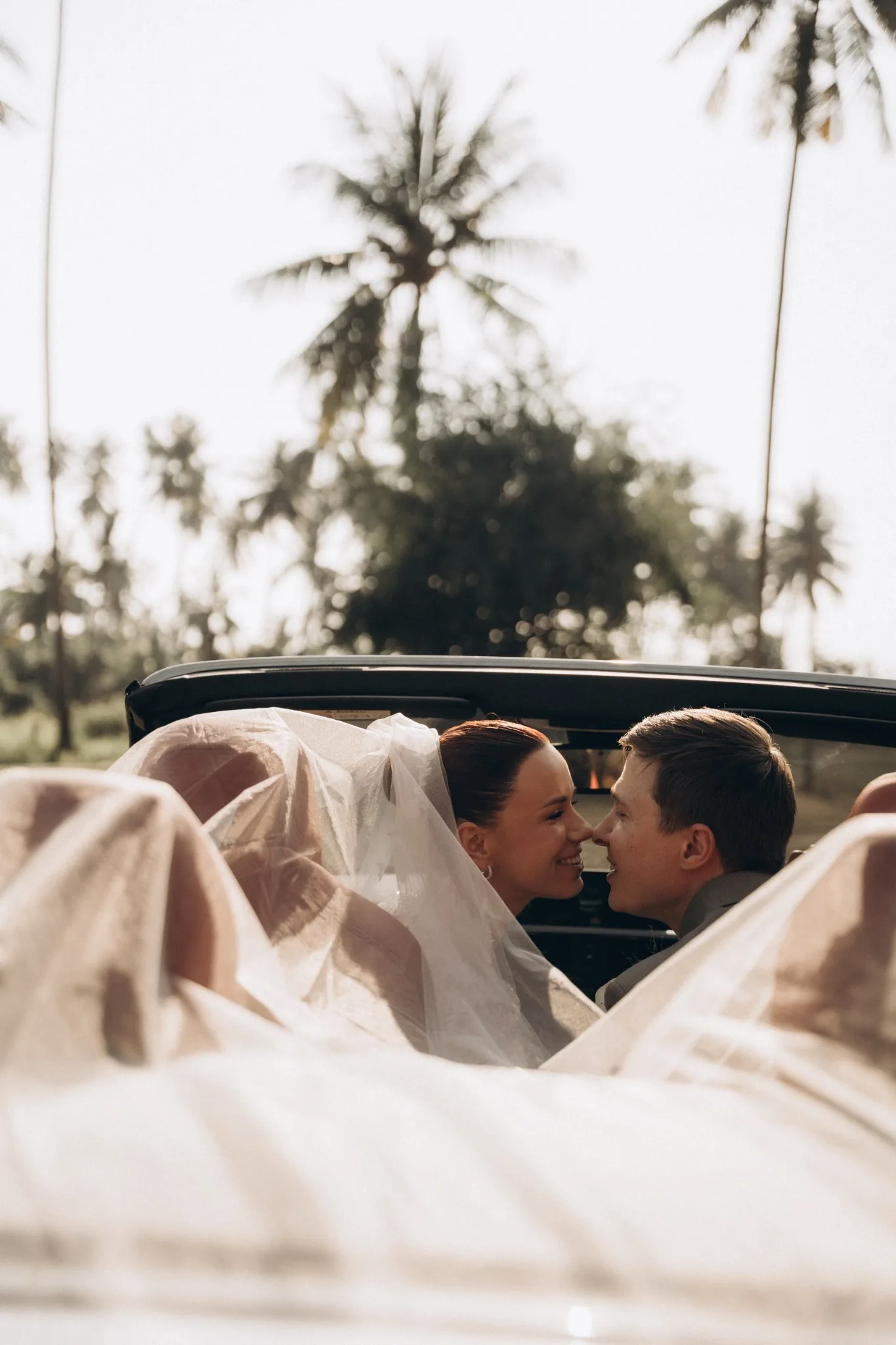 Bride and groom standing on a blue-and-white church balcony in bright daylight