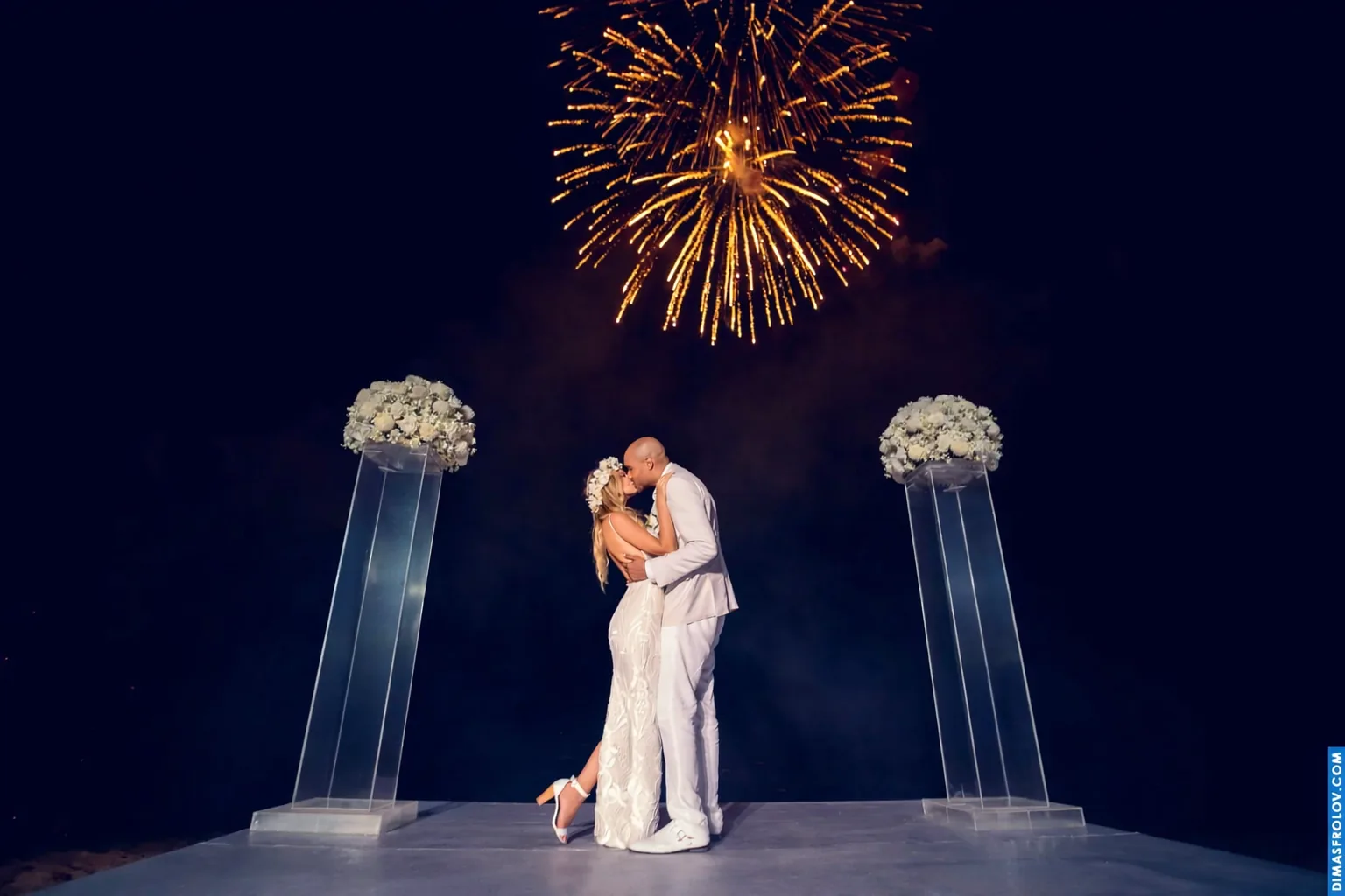 Bride and groom walking through their wedding celebration with spark fountains